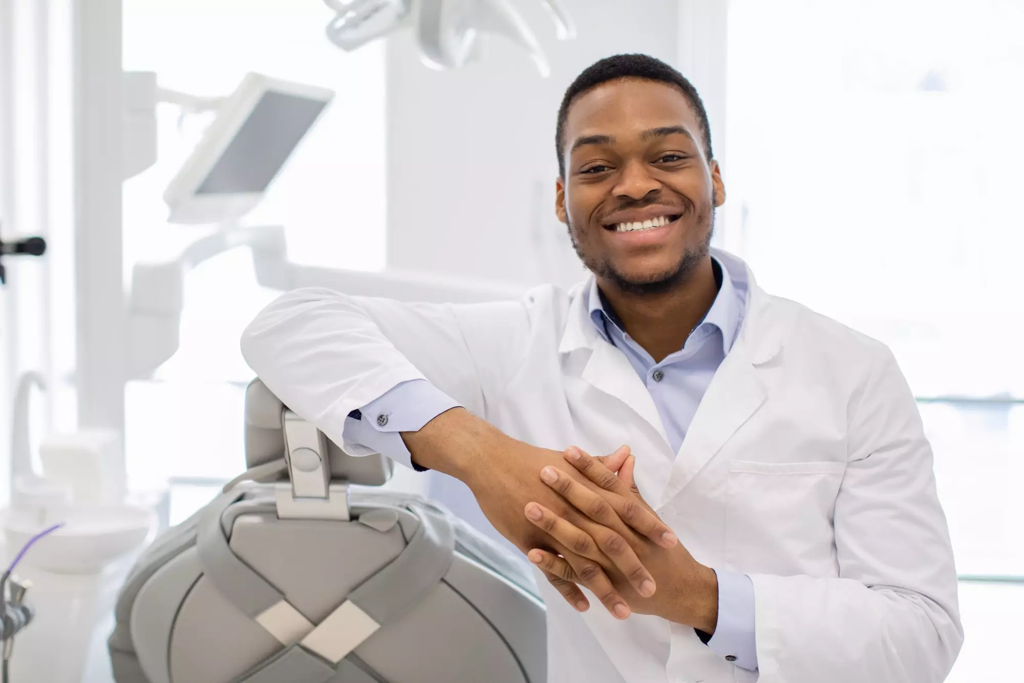 Professional Black Orthodont Doctor Posing At Workplace In Modern Clinic