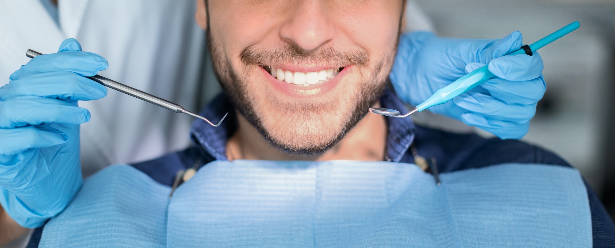 Unrecognizable male patient having teeth whitening procedure