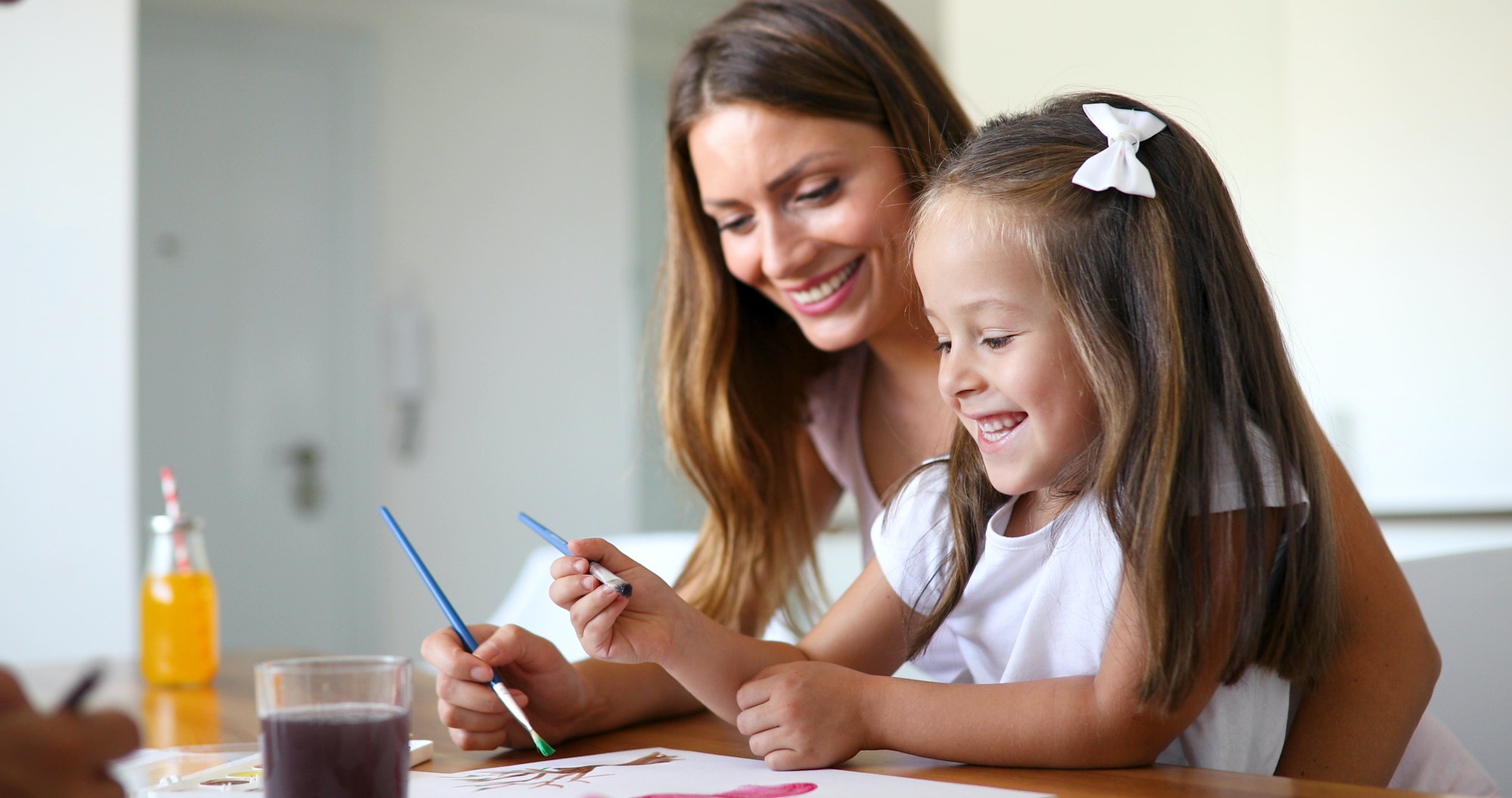 Little girl painting with her mother at home