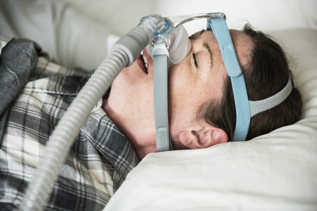 woman sleeping with anti snoring chin strap